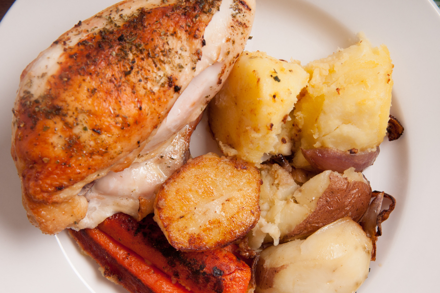 Roasted pasture raised split breasts chicken from our local poultry delivery to Raleigh, served with roasted potatoes and carrots