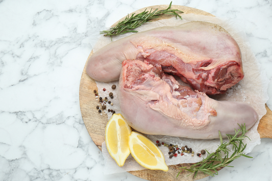 Two pasture-raised local grassfed beef tongue from Carolina Pastures in Hurdle Mills, NC on a cutting board with lemon and spices.