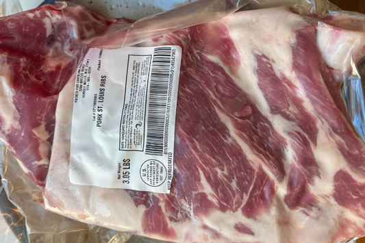 Packaged raw local farm pastured pork st louis ribs also known as spare ribs with a label on a vacuum sealed plastic