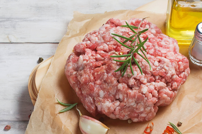 Raw local ground pork on a wooden board with herbs and spices, forest raised, antibiotic-free pork near me NC