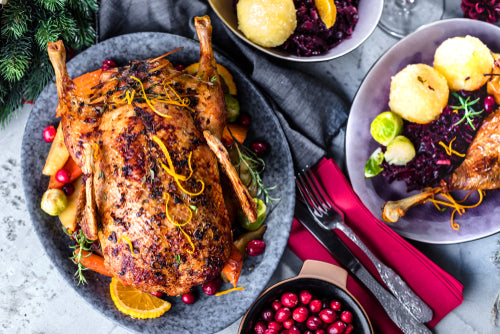 A north carolina farm fresh pasture raised roasted whole duck served on a platter with accompanying dishes.