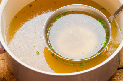 Pasture raised non GMO chicken frames used for a delicious bone broth in a silver pot.