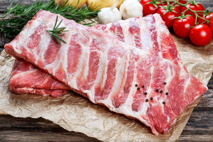 local farm pastured pork spare ribs, raw on a brown paper