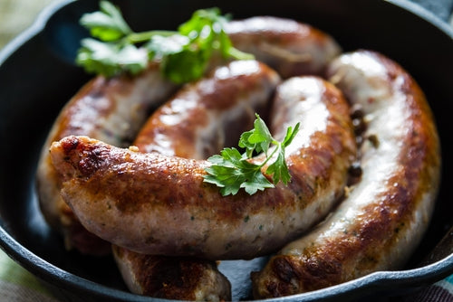 A pan of forest raised pork smoked polish sausage, also known as kielbasa, garnished with parsley.