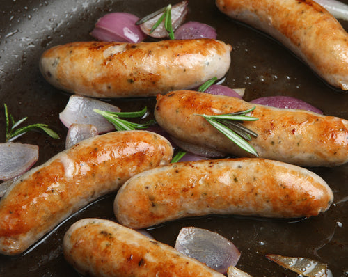 Local pastured pork breakfast sausage links in a skillet with onions and rosemary, non GMO pork