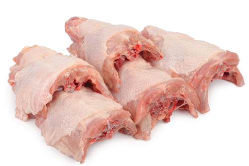 Raw pasture raised non GMO chicken backs on a white background from Carolina Pastures in Hurdle Mills, NC